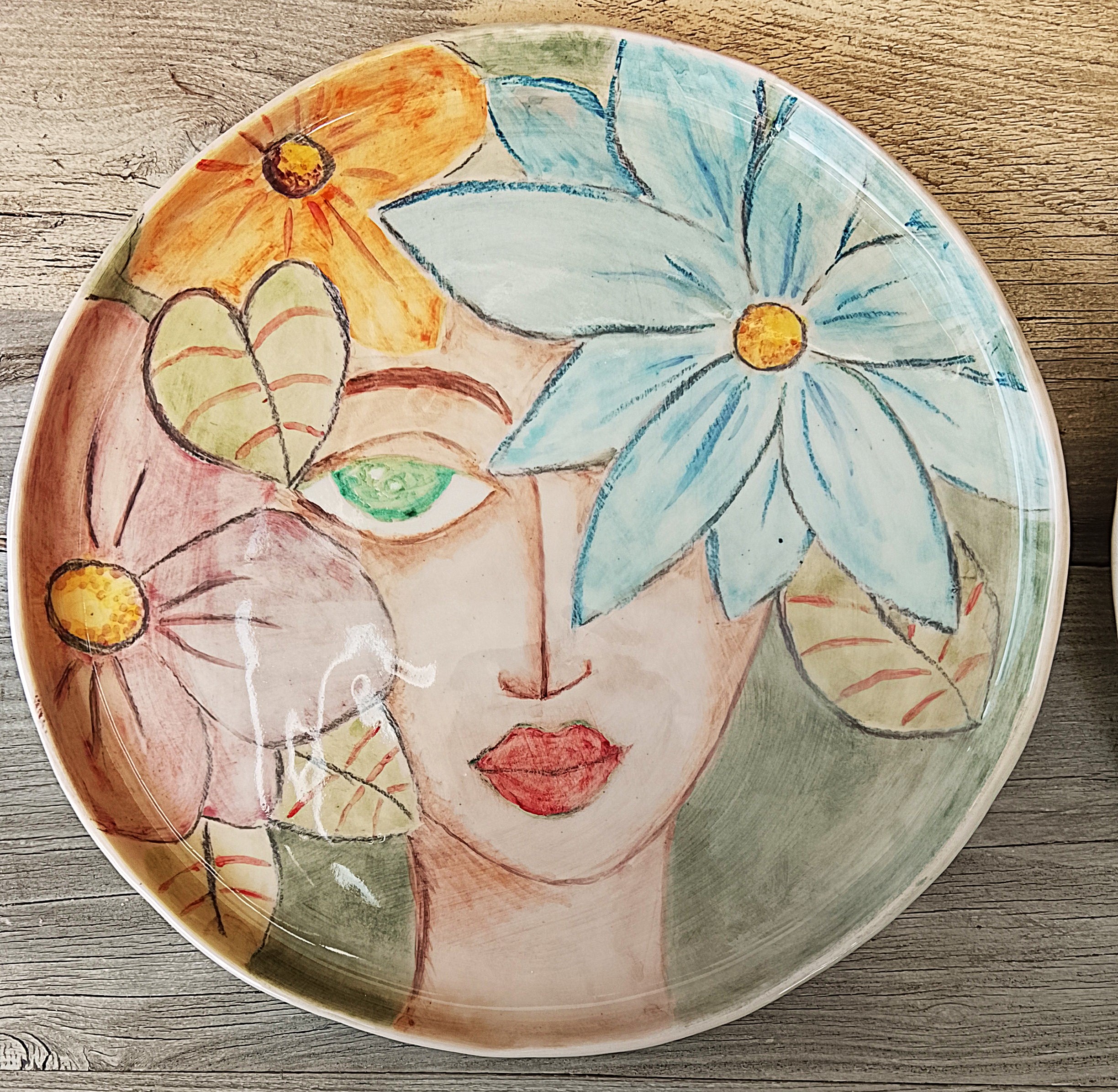 Piatto in ceramica dipinto con volto e fiori