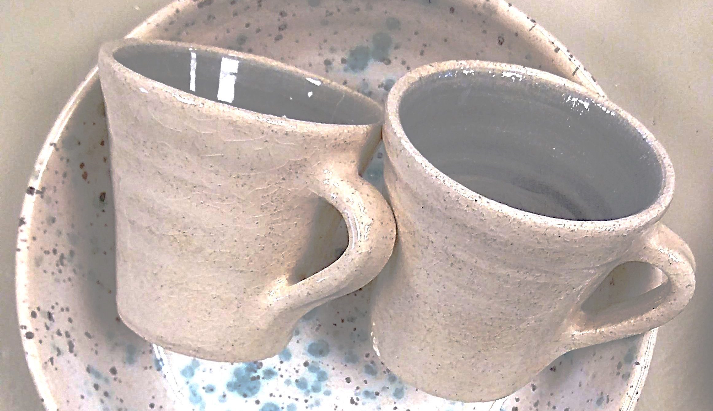 Due tazze in ceramica bianca su piattino maculato di azzurro