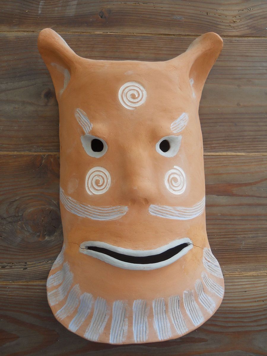 Maschera in terracotta con decorazioni bianche a spirale