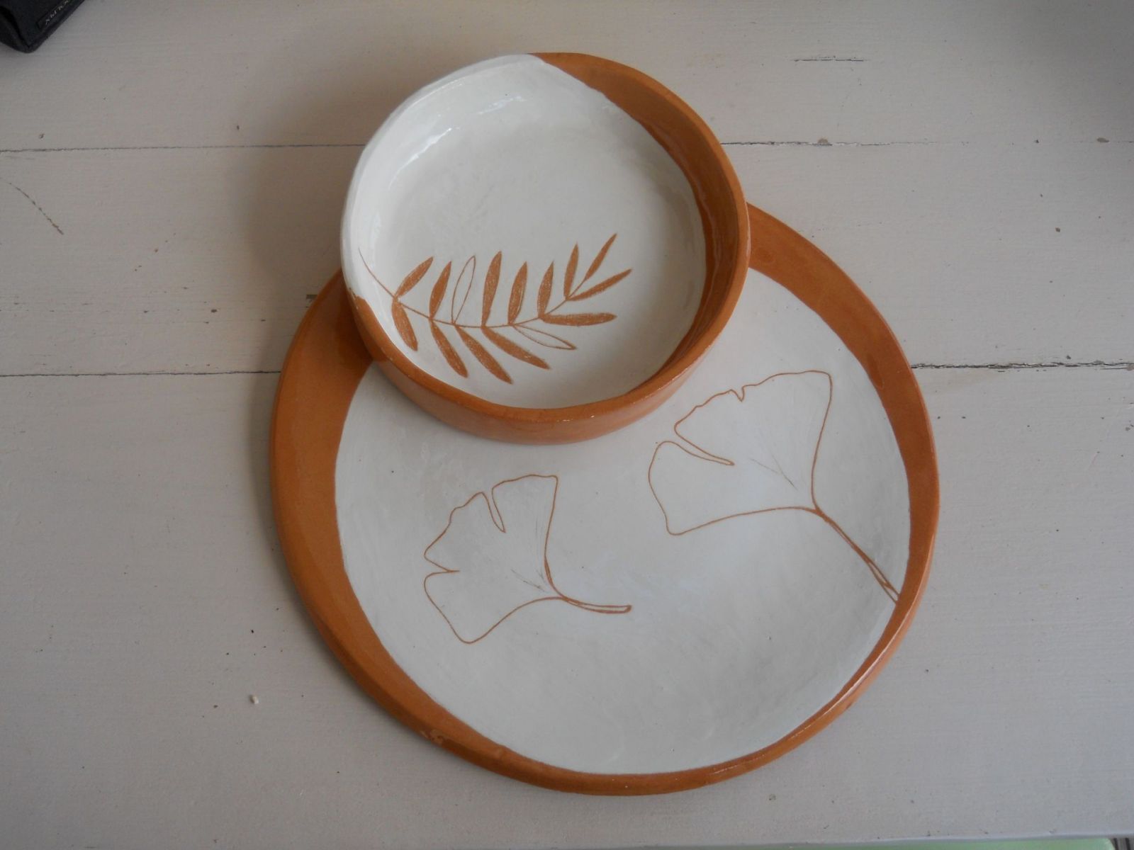 Piatto e ciotola in terracotta ingobbiati di bianco con foglie incise