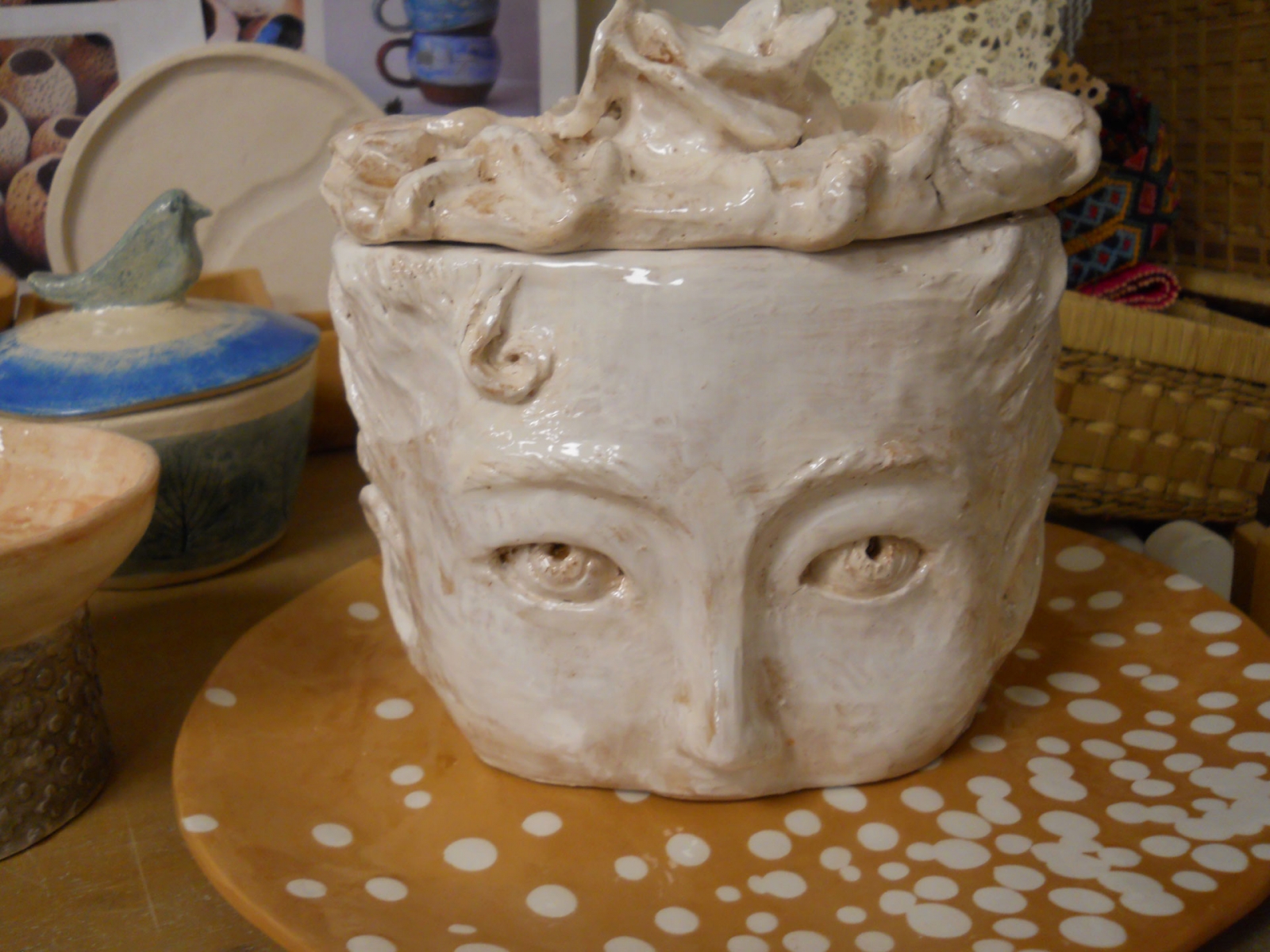 Vaso in ceramica con volto modellato e coperchio decorato
