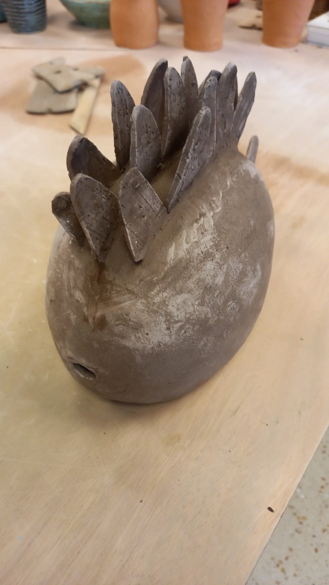 Scultura in argilla a forma di riccio con foglie in rilievo