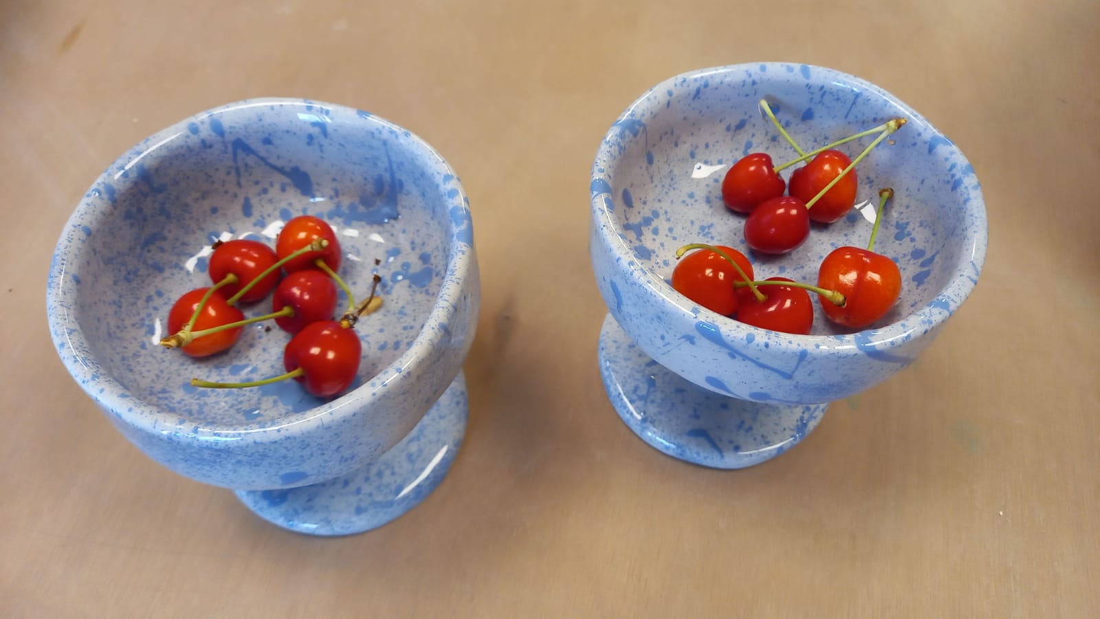 Due coppe in ceramica azzurra con bacche rosse