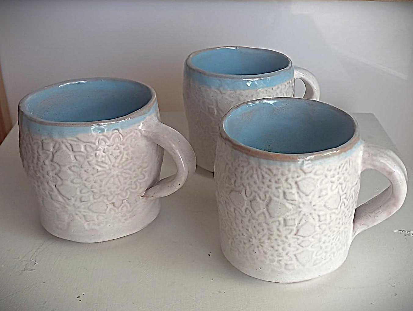 Tre tazze in ceramica bianca texturizzata con interno azzurro
