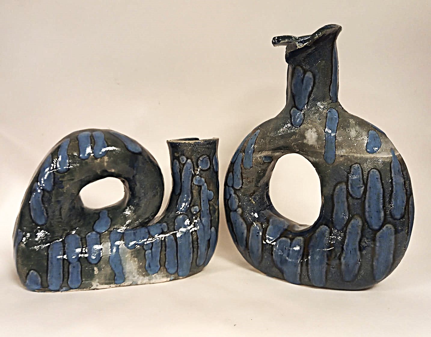 Due vasi scultorei forati smaltati in blu e grigio