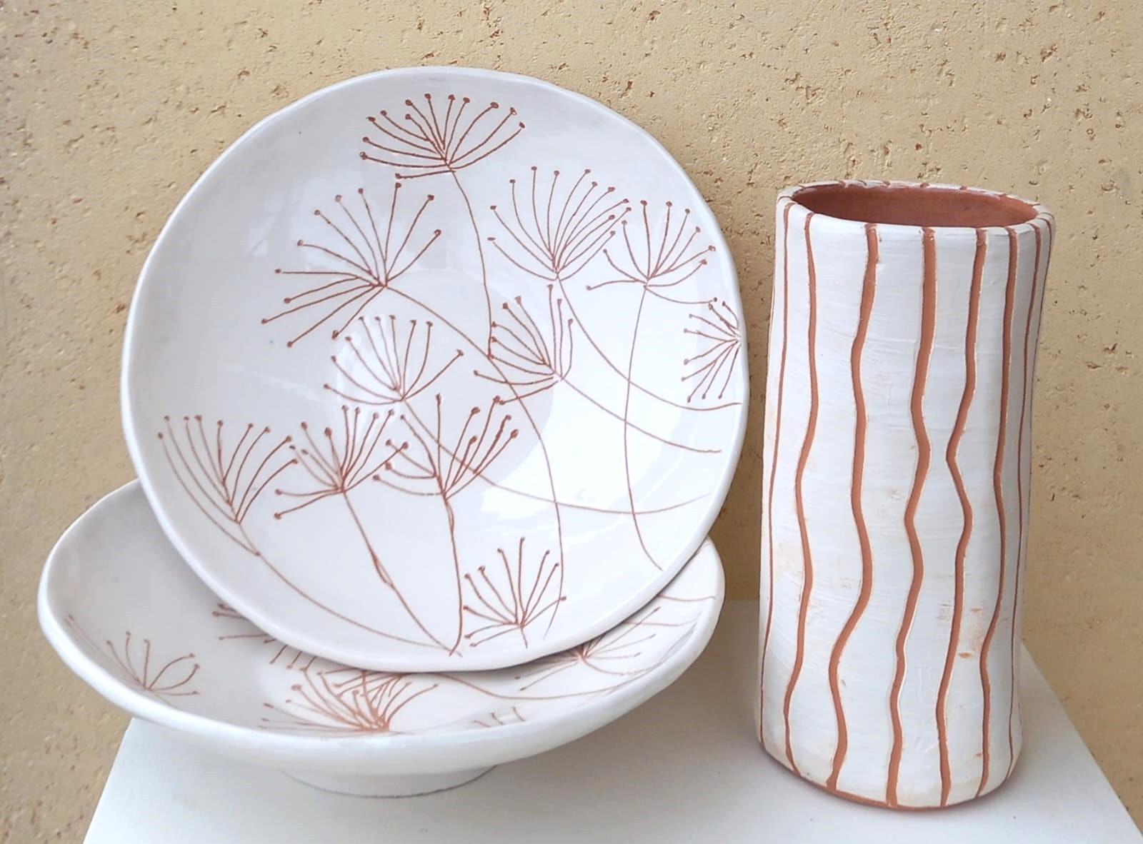 Piatti bianchi con decori floreali incisi e vaso a righe
