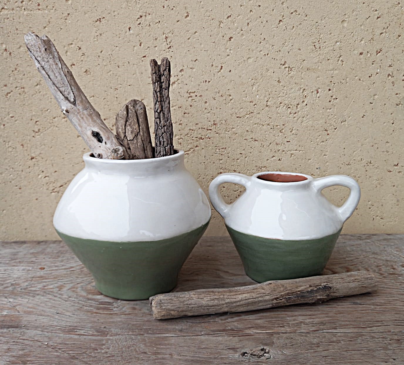 Vasi bianchi e verde salvia con rami secchi